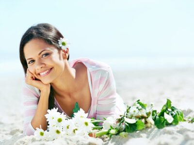 portrait of woman on beach with flowers relaxing in the sun