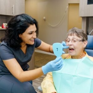dental patient looking at her teeth in a mirror