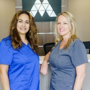 dental hygienists standing at front reception of local dentist office 