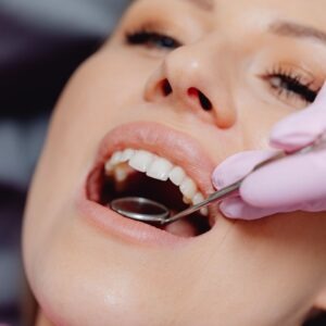 Looking behind a patients teeth with small mirror