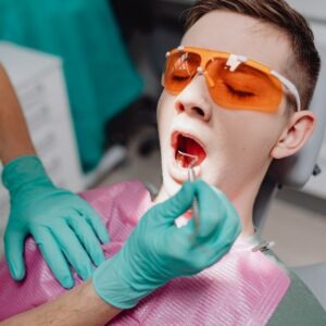 A patient with his mouth open getting teeth examined